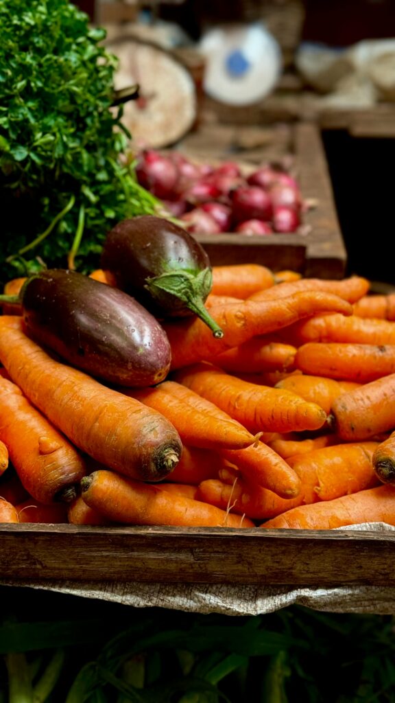 A vibrant display of fresh carrots and eggplants at a local market, highlighting healthy food choices.